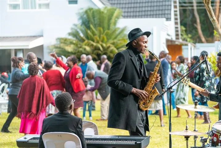 Jose Sax entertaining guests at a garden party